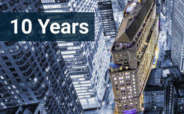 Looking down at the New York Fed main building at night with a text overlay of '10 Years'
