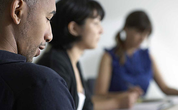 three people at a conference room table three people at a conference room table