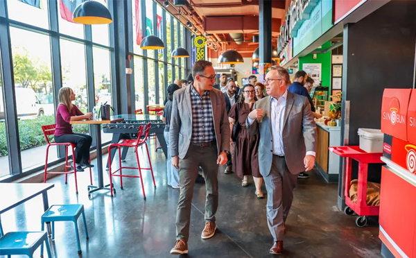 Pres Williams walking with business leaders and staff