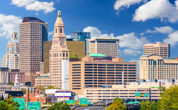 Skyline of Hartford, Connecticut against a blue sky with white clouds