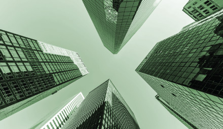 Looking up at tall glass office buildings with green overlay