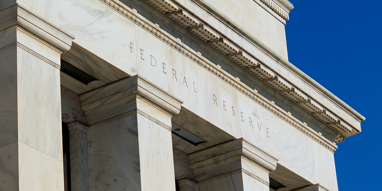 Closeup of exterior of Federal Reserve building against a blue sky