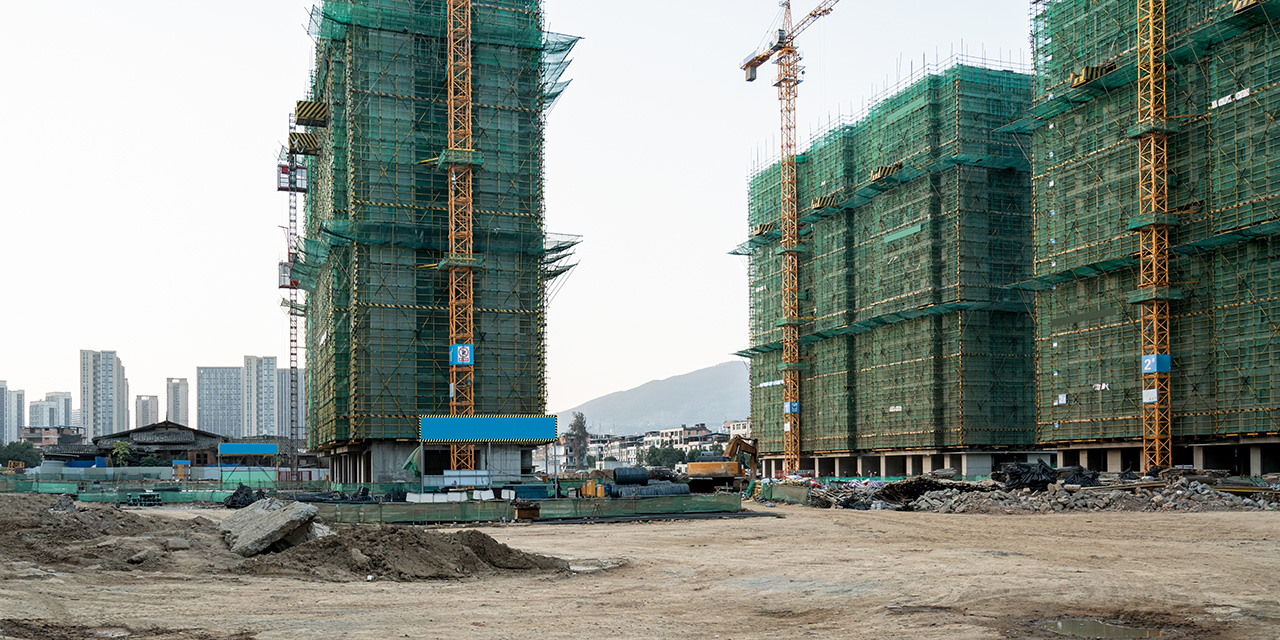 Construction site of three high-rise buildings covered in scaffolding