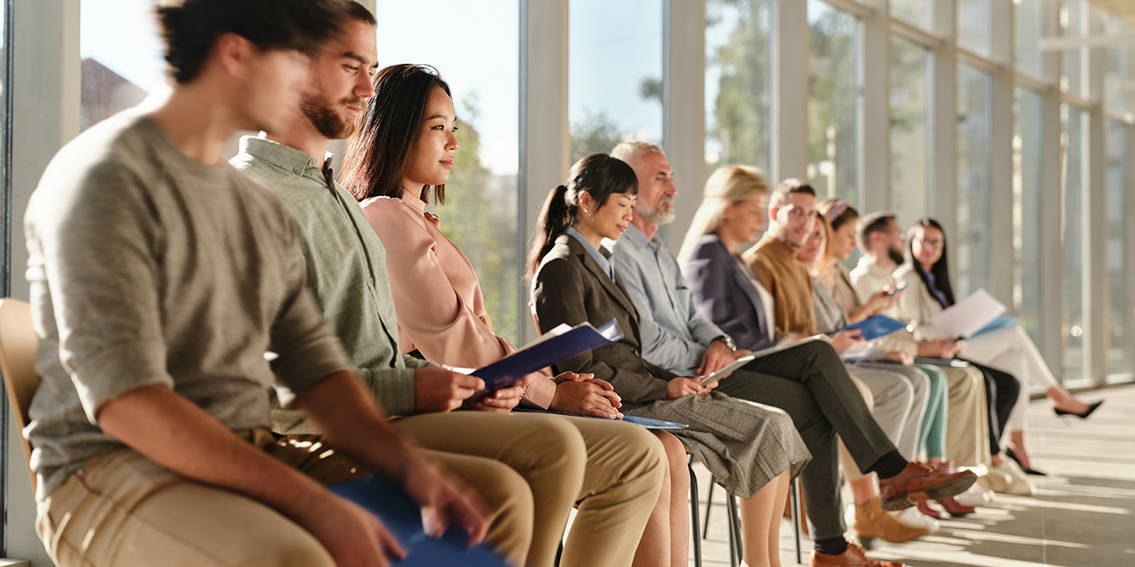 job applicants seated in a row in front of a bright window job applicants seated in a row in front of a bright window