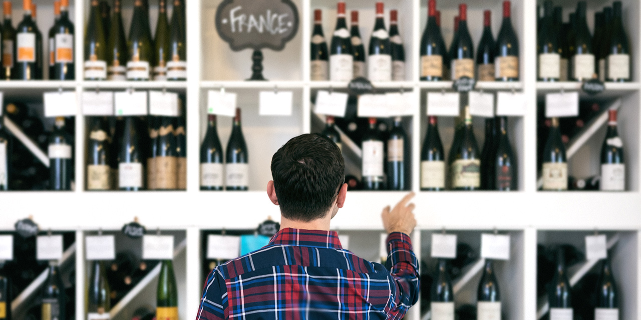 view of back of shopper looking at a wine display labeled "France"  